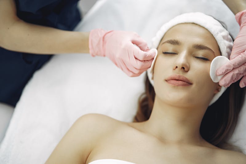 Application d un soin specifique sur le visage d une cliente